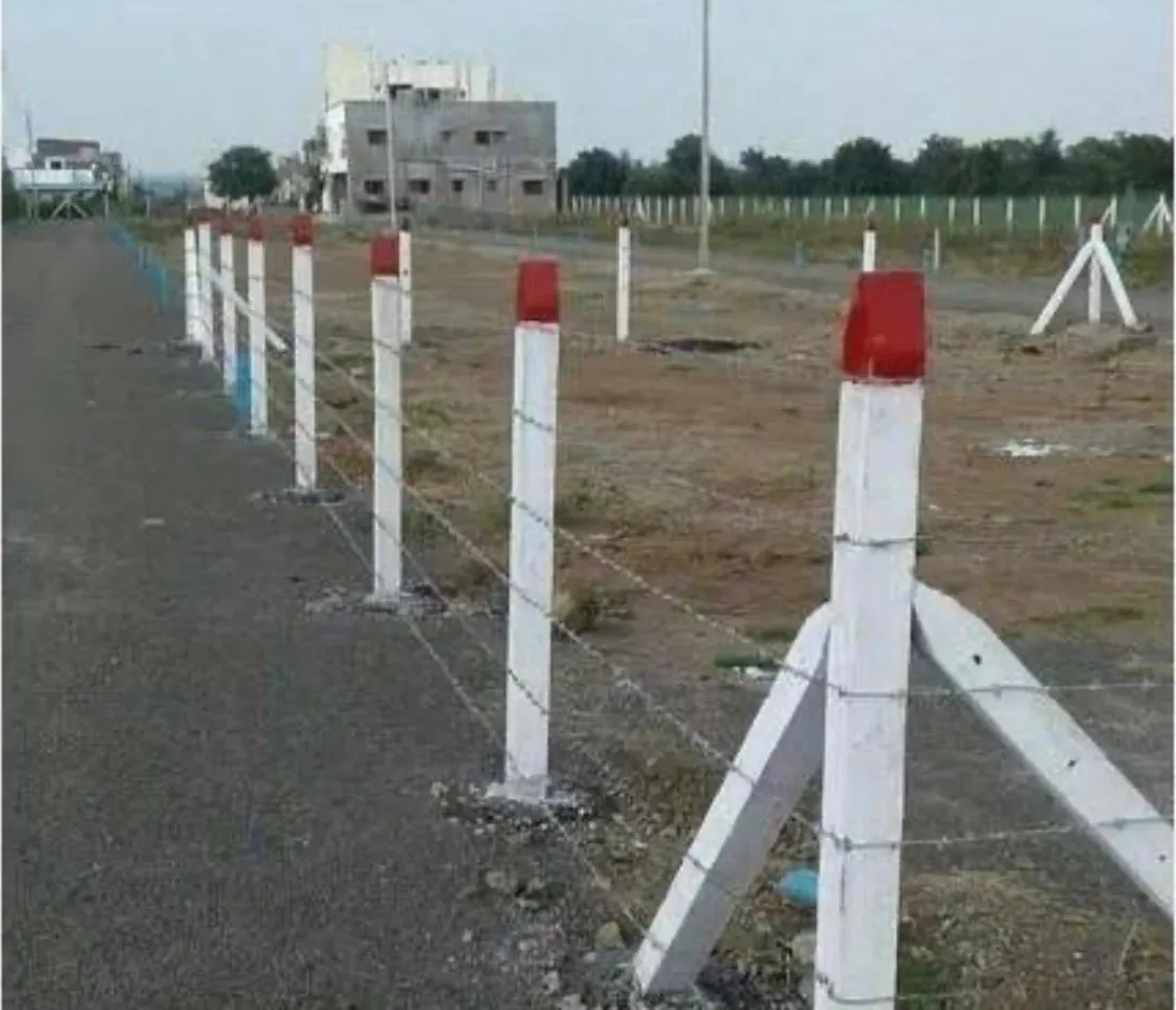 Barbed wire fencing on concrete posts beside a road